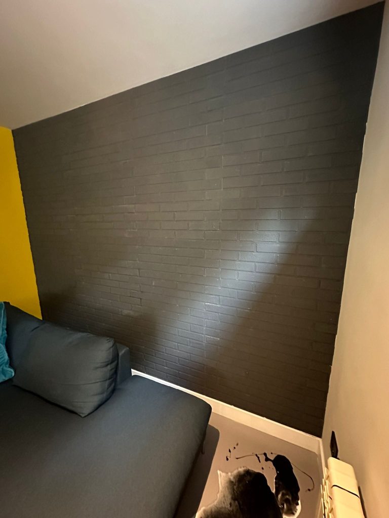 Pared con papel pintado oscuro de textura detrás del sofá
