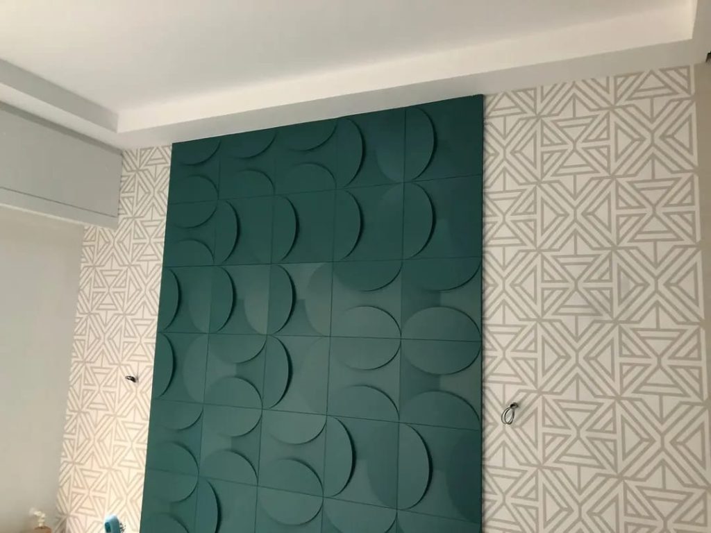 Pared con paneles decorativos verdes en relieve y papel pintado geométrico