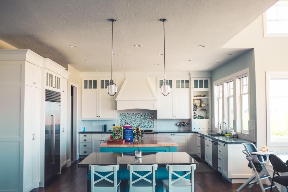 Cocina abierta y luminosa con muebles blancos y zona de comedor